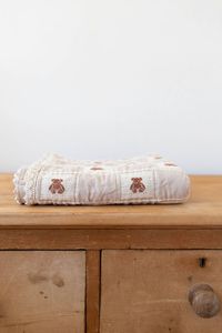 Add the perfect vintage-inspired, heirloom-quality piece to your baby's nursery with the patchwork teddy blanket by New Grain. The teddy blanket features detailed brown teddy bear embroidery with crochet trim around the edges. It measures 32 x 42 inches and is made of 100% organic cotton. Made in Portugal