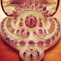 FRANCE_A 1820s three colour gold and amethyst grand parure comprising a tiara a pair of earrings a brooch, two bracelets and a necklace with girandole pendant. French.