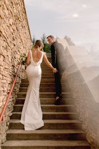 Stairwell wedding photos, staircase shot, bridal portraits, clean bride, outdoor wedding photos, classy photos, Satin low back wedding dress, groom black tux, wedding venue, creamy wedding photos, minimal gown, wedding gown pictures