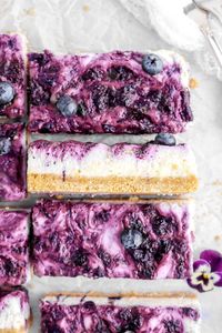 Get ready to find your new favorite no bake treat with these super simple Lemon Blueberry Cheesecake Bars! Tangy, rich lemon cheesecake, swirled with homemade blueberry jam, all atop the easiest 3 ingredient graham cracker crust. So simple, but SO delicious!