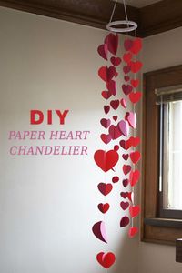 DIY Paper Heart Chandelier: Hang this easy and cute paper heart chandelier over any light fixture for a fun V-Day decoration. Click through to find more DIY Valentine's Day decorations for your home.