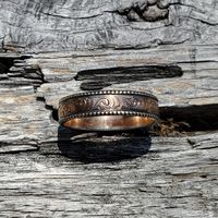 Introducing the Levi, the men's band as seen in the Lorna set! This handsome ring is made from 10K rose gold, with a sterling bead edge. It features swirling hand-engraved details, which wrap continuously around the middle section of the ring.  There are two finish options for this Western wedding band- bright and antiqued. Choose bright to leave the ring shiny, or go with antiqued to add black to the engraving.  We make each piece by hand, one at a time, for every order. Because of this, your f