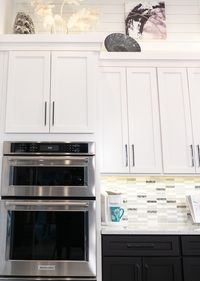 The straight lines of our Colonial cabinets and crown molding pair handsomely with the backsplash and shiplap of this tuxedo kitchen.