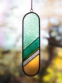 Handcraft stained glass panel in green tones. An elegant and minimalist decoration that looks beautiful both on the wall and hung in the window. Made of stained glass of various colors and structures. Due to the nature of the glass, the colors change depending on the light source. Depending on the angle of light and panel exposure, we can obtain different effects each time. Panel creates colorful beautiful shadows when hung in a sunny place.