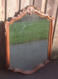 This carved walnut french wall mirror is offered in very good condition. The mirror has a swept frame with floral carving and a central acanthus leaf. The frame has been polished and the mirror is in good condition.