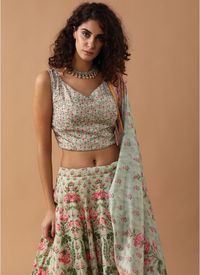 This artistic floral print moss green crepe sleeveless crop top with sweetheart neck is teamed with a printed bias cut skirt and a dupatta.