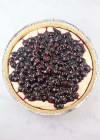 This creamy, delicious, easy Lemon Blueberry No-Bake Cheesecake (with fresh blueberries!) is seriously amazing. With a crunchy graham cracker crust, a sweet & tart lemony cream cheese filling and homemade blueberry pie filling on top... you will want to lick the plate when you finish a slice. #lemon #blueberry #blueberries #cheesecake #nobake