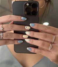 cutesy blue, beige heart nails with a tulip accent nail design on the thumb