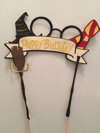 ***Notice: new packaging. Due to previous concerns, these are now packaged in a corrugated flip top box in order to prevent damages. This Harry Potter cake topper has it all...the hat, the glasses, the scarf, the wand, and a quidditch broom. It measures 8 wide and 9 high. The wooden sticks add 4 to the height. Those 4 inches will be in the cake so you can fully see all of the cake topper. ***Due to the post office delivering a few of these broken, as well as to keep shipping charges low, Im n...