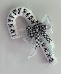 Buffalo Checker black and white ribbon makes for a beautiful elegant winter or Christmas decor. This wreath can be hung two different ways as shown in photos. The candy cane makes a great gift for someone at the office, will look great on door during the winter season. It will put a smile on anyone's face..  Its definitely one of kind design.. I design these wreaths with careful thought and care.  Materials: * Metal frame * Polyester  * Cotton (yarn) * Wire Measurements:  22" inches Length  12"