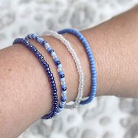 Delicate blues mixed with a pearlized white will make you feel like you're in the clouds when you wear this stylish set. Looks great paired with jeans and a white tee or an all white outfit you want to add a pop of color to. Mix n match with my other bracelets for endless styles! You will receive 4 bracelets in this set. Each piece is handmade with: - High Quality Glass Seed Beads - Stretch Cord: High-quality cord with reinforced knots Easily layer with other Luna by Rachel bracelets for a stunn