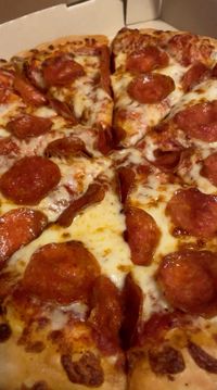 Indulge in the mouthwatering flavors of a classic pepperoni pizza, crafted to satisfy your cravings with its irresistible taste and comforting familiarity.