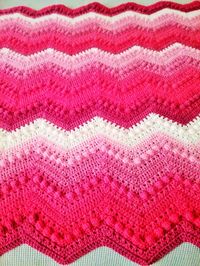 Hand crocheted afghan in the popular Hugs & Kisses design.  Would make a great gift!  Made with soft, acrylic yarn in multiple  colors that would appeal to young & old.  Coverlet is soft & cuddly while being lightweight and warm.  Size 30" X 40".  Machine wash cold, tumble dry low.