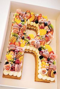 RUDECO SIGNATURE DESIGN! Tropical fruit, Macarons and flowers 🍓🍊🍍 Variety of fruit, flowers, macarons and special chocolates with our famous French Vanilla Cream and our almond crispy dough. Large size letter cake is only $128 up to 18ppl ✨✨ Order yours today!