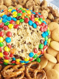 Monster cookie dough cheeseball dip has no eggs and no flour! Everything you love about monster cookies; oats, peanut butter, chocolate chips, and m&m's but in a fun and tasty cheeseball. Serve with pretzels, graham crackers, and cookies.