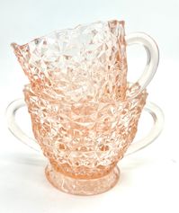 This sugar bowl and creamer set is absolutely beautiful! This set is from the Jeannette Holiday Button and Bows circa 1940s.  Beautiful pink depression glass with a very intricate pattern.  Excellent vintage condition! Both measure 3.25" tall.  Our items are antique or vintage pieces. It is normal to have some imperfections. That added character is what we love most about our pieces! Be sure to look over all photos and see the description, as we do our best to show all flaws. If you have any questions feel free to reach out. Thank you kindly A Simpler Time & Co