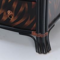 A Maitland Smith ebonized five drawer bow front commode having exotic flame painted decoration and leather wrapped trim. Each drawer is adorned with lion faced drawer pulls.