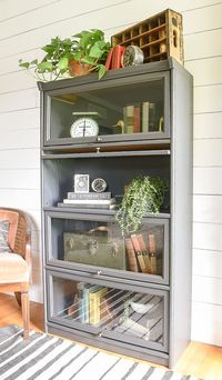 Styled with unique vintage finds, this old oak barrister bookcase gets a fresh modern makeover with Sherwin-Williams Iron Ore. #furnituremakeovers #barristerbookcase #paintedfurniture #ironore #beforeandafter