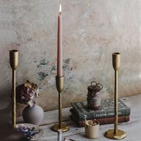 Our iron candlesticks with antique gold finish have an elegant stem and are designed to hold a standard dining candle. sold individually handmade in India small: 7 3/4" tall medium: 11 3/4" tall large: 15 3/4" tall will have slight variations in design and size as this is a one-of-a-kind handmade product PLEASE NOTE: these handmade iron items are perfectly imperfect