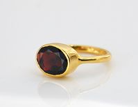 This beautiful stackable bezel set ring is made with oval faceted natural Garnet Quartz gemstone in 18K Vermeil Gold. The ring has a 925 stamp.