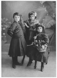 Three young Armenian girls, one holding a basket of roses. (From left to right: Rebecca H. Hazarian, Yevnige Hazarian, Araxi Hazarian; daughters of Hagop Hazarian). Constantinople, Ottoman Empire (now Istanbul, Turkey), ca. 1912.