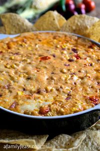 Southwestern Cheesy Corn Dip - Seriously, the best dip we've ever had! Creamy, warm and cheesy with fresh corn kernels, diced tomatoes and seasonings. YUM!