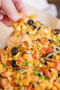 Chicken Nachos are easy, cheesy, and loaded with layers of chicken, veggies and cheese. This easy nachos recipe is perfect for one or a crowd.