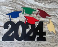 "Upgrade your senior photo session with a graduation sign for the Class of 2024.  To customize each of your photography sessions our cap is interchangeable to add a touch of your senior's school color.   Measures 11\"h x 18\"w and each layer is cut from premium 1/8\" wood.  Sturdy and lightweight. Includes: - 1 Deluxe Sign with a black year and white background - 17 caps in black, white, gold, silver, rose gold, navy, blue, light blue, teal, green, purple, pink, maroon, red, orange, yellow and g