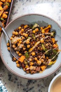 Roasted lentils and chickpeas are served with roasted vegetables, sweet potato, and a simple maple tahini drizzle in this high-protein vegetarian sheet pan dinner. This recipe works with canned lentils or lentils cooked from dry!