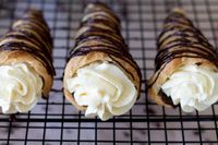 This indulgent recipe for Dark Chocolate Cream Horns makes puff pastry cornucopias filled with dark chocolate and Chantilly cream. The chocolate on top gives this recipe a double dose of chocolate, making it one amazing dessert.