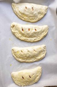 Take pizza night up a notch with these sourdough calzones. Made with a flavorful sourdough crust, fill each calzone with sauce, cheese, and your favorite pizza toppings, like red onion, green peppers, or sausage - the options are endless! #FarmhouseonBoone #SourdoughCalzone