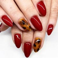 Red classy holiday nail art with touches of tortoise shell print to spice it up. These tortoise shell nails are the perfect winter manicure. #rednails #holidaynails #christmasnails #tortoiseshellnails @nailthoughts