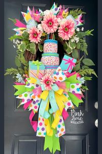 Birthday wreath for front door in bright happy colors! Made with artificial birthday cake and gift attachments.