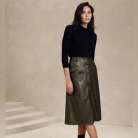 -Vegan Leather Skirt, Size S, In Olive Green Color -Lightweight, Smooth And Soft -Button Front Closure -Belt Loops -Front Pockets -Waist Darts - High Waist -Full Hem -Fully Lined -Base Fabric: 100% Rayon -Outer Coating:Polyruethane