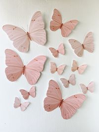 "Set of 12 hand cut paper butterflies in peachy pink colors Ranging in size from 5.3\" to 11\" wing span Printed on card stock paper, back side white Double sided printing available at checkout Package comes with glue dots and tracking ::paper butterflies can be made from 2\" to 15\" wing spans for custom orders TO ORDER IN DIFFERENT COLOR see alternate color options in last photo. purchase this listing and add corresponding #s in a note to seller at checkout choose up to 3 colors, or message me