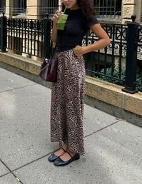 Recreate this leopard skirt outfit with mary jane flats, a black t-shirt, and a burgundy bag for your fall 2024 outfits!