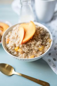 Sweet and Creamy oatmeal with ripe peaches sautéed in brown sugar and a healthy drizzle of cream at the end. A decadent breakfast in a bowl.