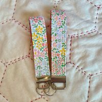 Add this Pretty Floral Wristlet to your keys, wallets, and more! Each keychain comes in two sizes, either 5 inches or 5.5 inches. The lining fabric is a pretty coral with a subtle daisy print that coordinates with the outer fabric. These keyfobs are sure to bring a smile to anyone who receives one! Each pattern/color is made in a limited quantity, so get yours while it lasts! ** Products are handmade in a smoke free, pet free environment and most are ready to ship.  ** Due to being handmade, there may be slight variations in size and pattern placement.