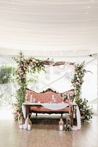 floral arch backdrop with a pink velvet sofa wedding sweetheart table