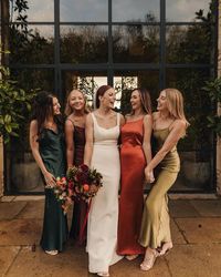 Mismatched tonal silky bridesmaid dresses for this stylish autumnal wedding at Old Gore Barn, a rustic, foodie wedding venue in Gloucestershire.