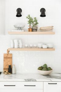 Natural wood open shelving styling in a modern white kitchen with leather stools and a thick marble island | Studio McGee Design Blog