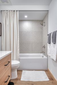 These textured oversized tiles make a great bath tub surround in this modern mountain bathroom remodel.