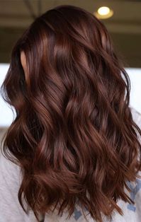 10. Chestnut Waves with Auburn Lowlights Enhance your natural curls with subtle auburn lowlights for added dimension and depth, resulting in a