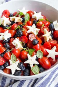 This fun and patriot Blueberry Tomato Caprese Salad is red, white and blue and perfect for serving as a side dish for any American holiday. #caprese #4thofJuly #redwhiteblue #memorialday #sidedish #salad