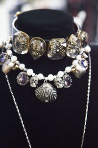 A jewelled insect charm choker and a beaded shell necklace. Photographed in the Alexander McQueen atelier.