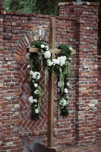 Simple cross with greenery draping is the perfect ceremony backdrop! #carlhouseflorals