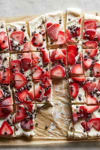 Lightly sweetened Greek yogurt gets studded with fresh strawberries and chocolate chips then frozen so you can break it into chunks just like chocolate bark (but healthier). This colorful snack, or healthy dessert is perfect for kids and adults alike. Use full-fat yogurt to ensure the creamiest bark possible. #healthysnacks #snacks #snackideas #healthysnackrecipes #healthysnackideas #recipe #eatingwell #healthy