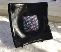 "This art glass plate was made with glossy black glass with a center square of patterned iridescent glass which has the beautiful shimmer and sparkle of dichroic glass. This gorgeous art glass dish will look fabulous on your dresser, vanity or desk and is perfect for jewelry, trinkets, small candies or a candle. Measurements are 6 3/8\" square with a 1 1/4\" rise at the corners. Designed and handmade in my home studio in North Carolina. For more of my handmade glass items, please click here: htt