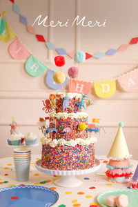 Add maximum impact to birthday celebrations with a tiered sprinkle cake decorated with fun toppers. Don't forget bright banners and accessories for the ultimate party backdrop!