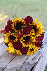 Wedding Bouquet filled with dyed sunflowers, berries, and Rosa Black Baccara roses.